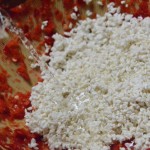 つぶしたトウガラシに、同量のこうじをほぐし入れ、水を加えて混ぜます