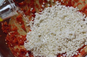 つぶしたトウガラシに、同量のこうじをほぐし入れ、水を加えて混ぜます